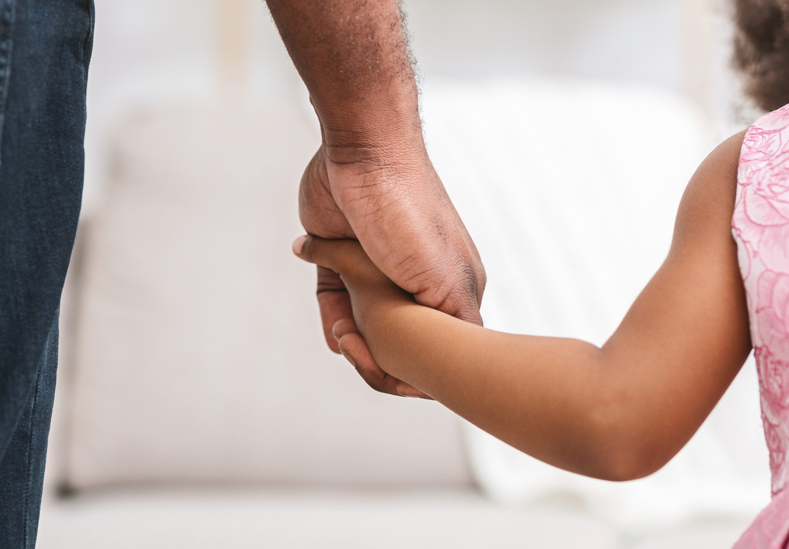 Close up of father giving hand to his daughter